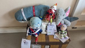 Pollito and the gang of DebConf mascots wearing their conference badges